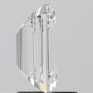 May include: A clear, faceted, rectangular-shaped diamond with a slightly rounded top. The diamond is set on a black stand.