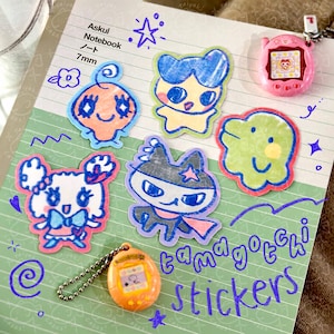 Adesivos holográficos Tamagotchi (com Mametchi, Kuchipatchi, Memetchi, Kuromametchi e Lovelitchi)