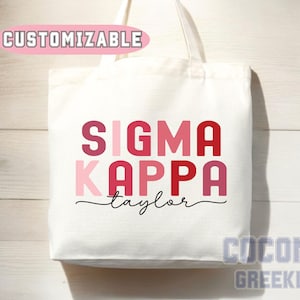 May include: White tote bag with a pink and red "Sigma Kappa" design and the name "Taylor" written below. The bag is customizable.