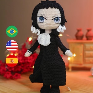May include: A handcrafted crochet doll depicting a character with black hair, blue eyes, and a black outfit with white details. The doll is standing and has a detailed face. The background is blurred, with warm lighting.
