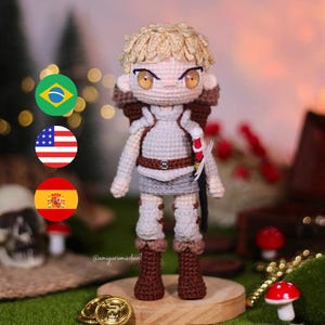 May include: A crocheted amigurumi figure of a person with blonde hair, wearing brown boots and a light brown outfit. The figure is standing on a wooden platform with gold coins and a mushroom in the background.