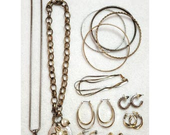 Lote de joias vintage em tons de prata e ouro, incluindo colar, pulseira e brincos em duas cores.