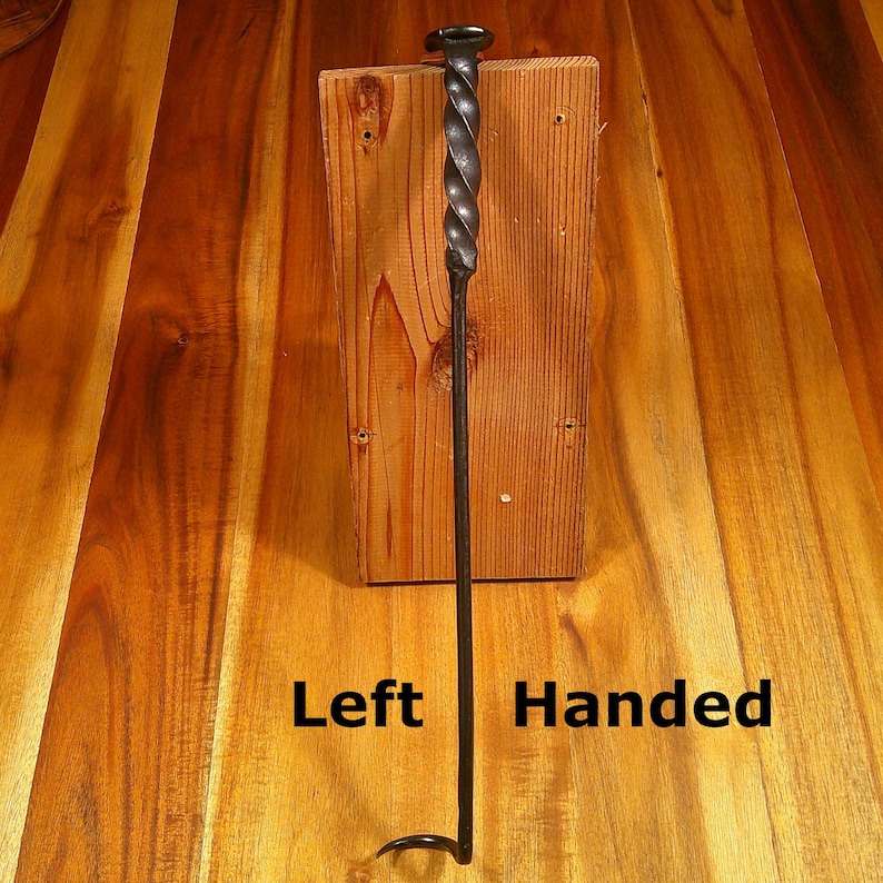 Puede incluir: Un atizador de chimenea negro para zurdos con un dise&ntilde;o de mango retorcido. El atizador es de metal y tiene un gancho en el extremo. El texto "Left Handed" es visible en la imagen.