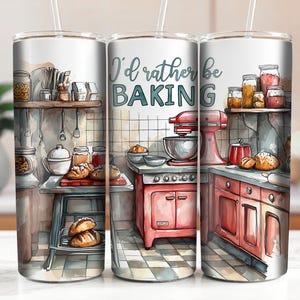 May include: A white tumbler with a watercolor illustration of a kitchen scene. The text "I'd rather be baking" is printed on the tumbler. The illustration includes a stand mixer, a countertop oven, and various baking ingredients.