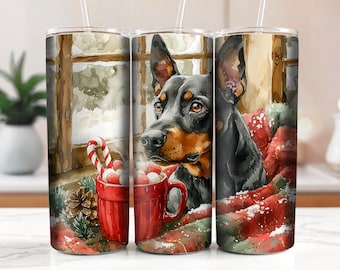 Könnte beinhalten: Ein schwarz-brauner Dobermann-Hund liegt in einer roten und weißen Decke zusammengerollt mit einer Tasse heißer Schokolade und Zuckerstangen. Der Hund schaut den Betrachter mit einem süßen Ausdruck an. Der Hintergrund ist eine verschneite Winterlandschaft mit einem Fenster.