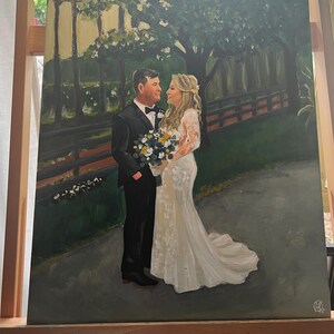 May include: A painting of a wedding couple standing in a green garden setting. The bride is wearing a white wedding dress and the groom is wearing a black suit. They are holding a bouquet of yellow and white flowers.