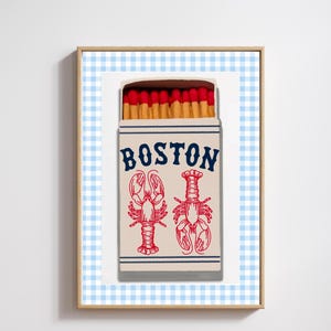 May include: A vintage-style matchbox with a red and white gingham background. The matchbox is labelled "BOSTON" in blue lettering and features two red lobsters on a white background.