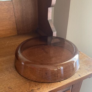 May include: A clear glass bowl with a brown tint, sitting on a wooden surface.