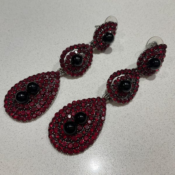 Pendientes colgantes vintage en forma de lágrima con piedras rojas y detalles centrales negros. Bisutería plateada.