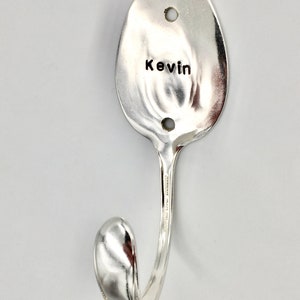 Peut inclure: Une cuill&egrave;re en argent transform&eacute;e en crochet avec le nom "Kevin" grav&eacute; sur le bol.