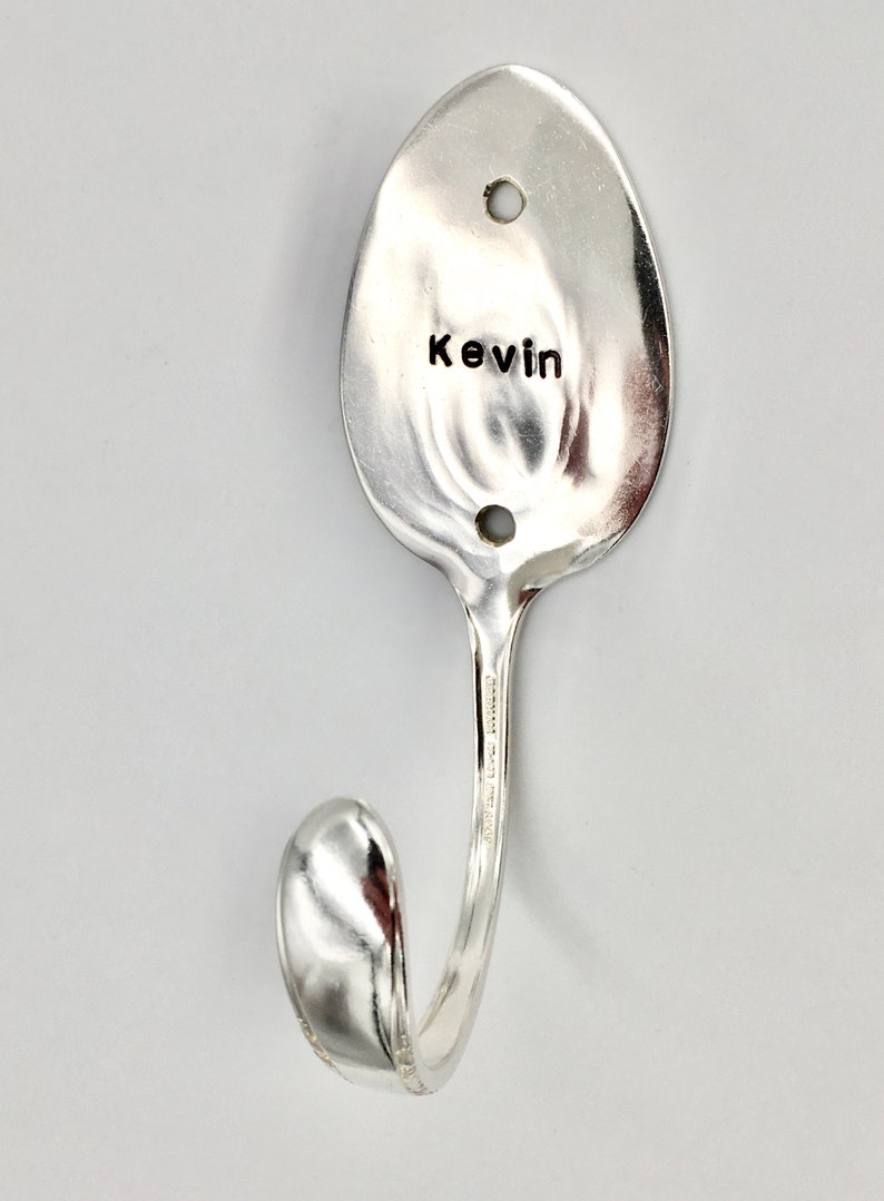 Peut inclure: Une cuill&egrave;re en argent transform&eacute;e en crochet avec le nom "Kevin" grav&eacute; sur le bol.