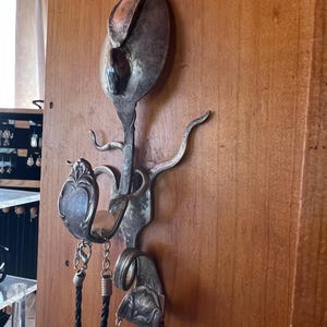 Silverskulptur med krokar och en polerad silverhematitsten