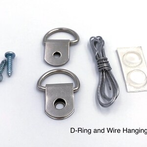 May include: A D-ring and wire hanging kit, including two D-rings, screws, wire, and bumpers. The kit is designed for picture hanging and includes all the necessary hardware for secure mounting.