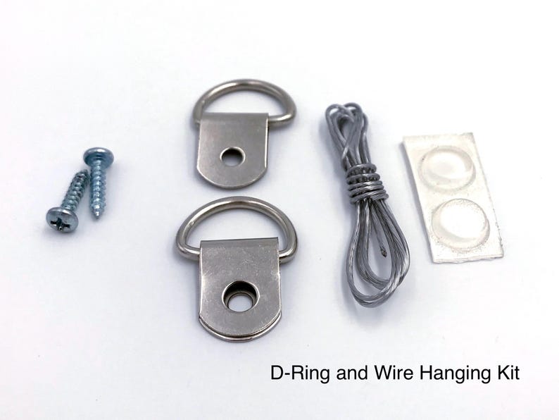 May include: A D-ring and wire hanging kit, including two D-rings, screws, wire, and bumpers. The kit is designed for picture hanging and includes all the necessary hardware for secure mounting.