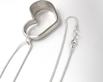 May include: A silver heart-shaped pendant necklace with a delicate snake chain.