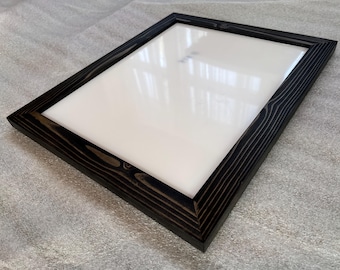 May include: A black wood picture frame with a white mount and a clear glass front.