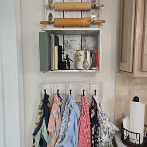 May include: A rustic kitchen storage unit with a shelf holding books and a mug, and a lower rack with aprons hanging from hooks. Two rolling pins are mounted above the shelf. The text "Customer DIY Image" is at the top.