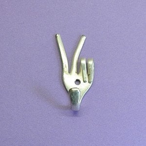 Könnte beinhalten: Ein silberner Haken in Form eines Peace-Zeichens, hergestellt aus einer recycelten Gabel.