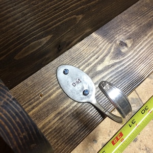 Peut inclure: Une &eacute;tag&egrave;re en bois avec une cuill&egrave;re en argent pli&eacute;e en crochet. La cuill&egrave;re porte la gravure "Dad" et est fix&eacute;e &agrave; l'&eacute;tag&egrave;re avec deux vis bleues.