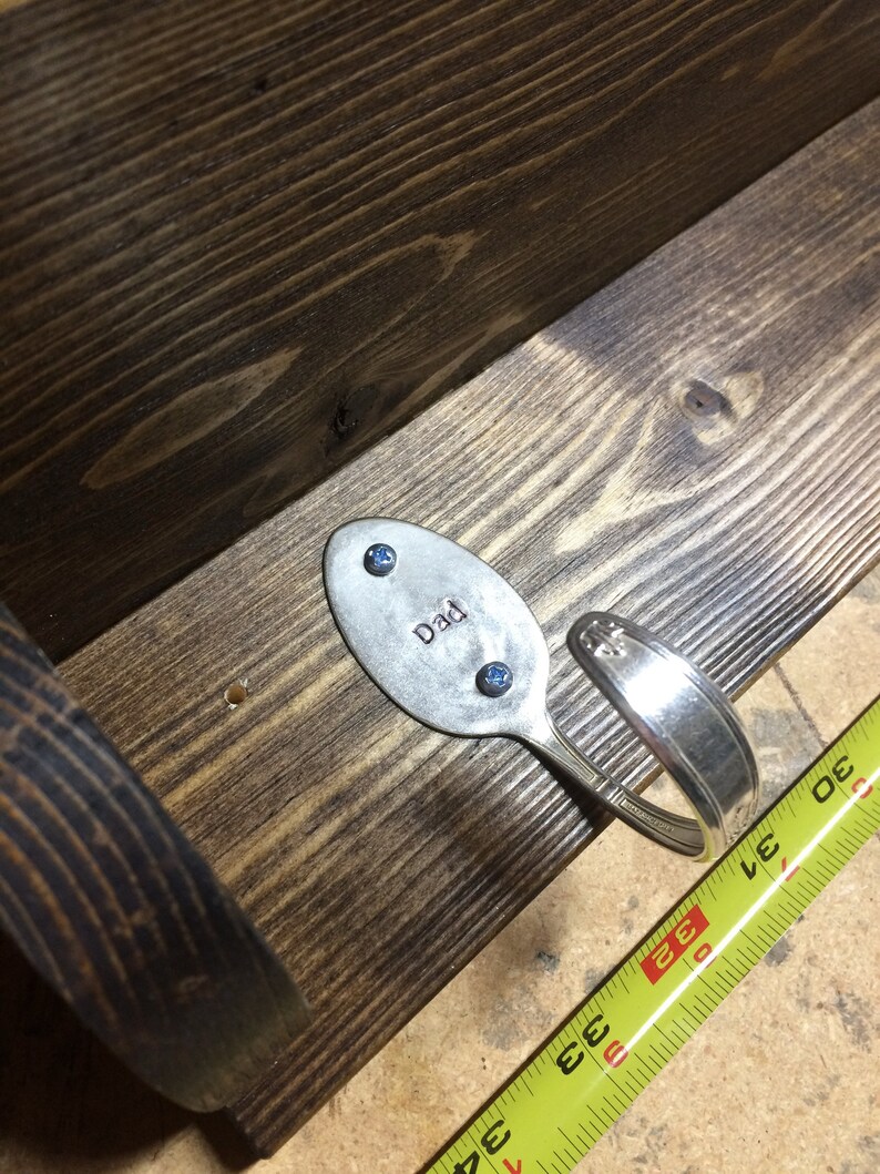 Peut inclure: Une &eacute;tag&egrave;re en bois avec une cuill&egrave;re en argent pli&eacute;e en crochet. La cuill&egrave;re porte la gravure "Dad" et est fix&eacute;e &agrave; l'&eacute;tag&egrave;re avec deux vis bleues.