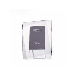 May include: A clear, angled photo frame with a dark gray insert. The insert has the text "DONOUCLS" and "2x3" Photoframe 5 cm x 7 cm". The frame is designed to stand upright and is made of a transparent material.
