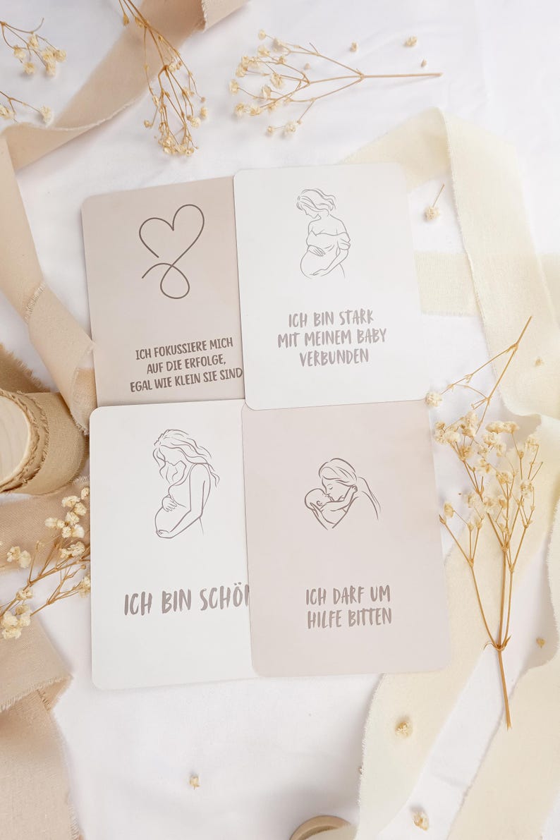 May include: Four rectangular affirmation cards with rounded corners, featuring line art illustrations and German text. The cards display drawings of a pregnant person and a parent with a baby, alongside phrases about strength, beauty, and asking for help.