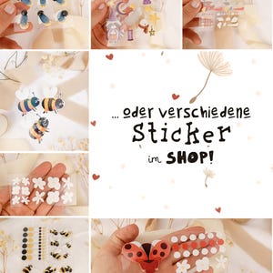 May include: A collection of clear sticker sheets featuring various designs including bees, Halloween characters, abstract shapes, white flowers, ladybugs, and dots. The image includes the text: ... oder verschiedene Sticker im SHOP!