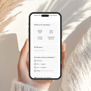 May include: A smartphone displays an event RSVP form with fields for name, attendance, and dietary needs. Options include "Joyfully Accepts" and "Regretfully Declines." The phone is held by a person, with a neutral background.