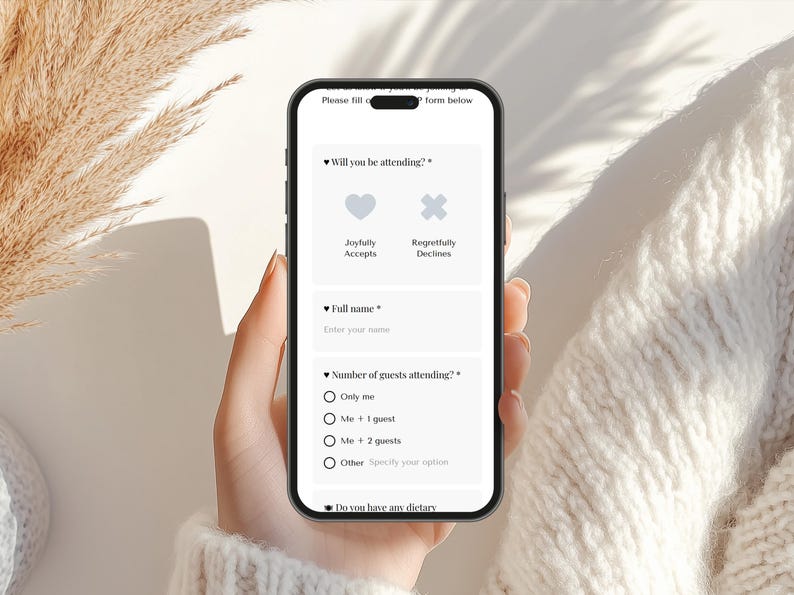 May include: A smartphone displays an event RSVP form with fields for name, attendance, and dietary needs. Options include "Joyfully Accepts" and "Regretfully Declines." The phone is held by a person, with a neutral background.