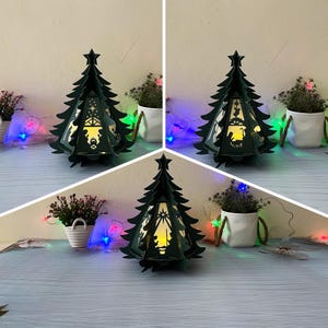 Könnte beinhalten: Drei grüne Weihnachtsbaum-Laternen aus Papier mit einem Ausschnitt einer Weihnachtsgeschichte. Die Laternen sind mit einem warmweißen Licht beleuchtet und von bunten Lichterketten umgeben.