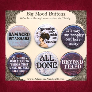 May include: Six round buttons with humorous sayings printed on them. The buttons are decorated with various patterns and images. The sayings include "Damaged but Adorable", "Quarantine only made me weirder", "It's way too peopley out here today", "No longer available for things that make me feel like shit", "All Done", and "Beyond Tired".