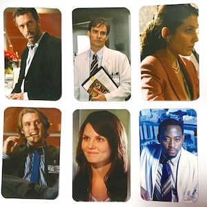 Puede incluir: Una taza de cerámica blanca con un asa negra y el texto "But First, Coffee" en negro y negrita. La taza está sobre una superficie blanca. La taza mide aproximadamente 10 cm de alto.