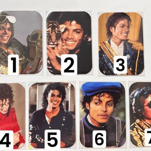 May include: A collection of seven rectangular stickers featuring images of Michael Jackson in various poses. The images showcase Jackson in different outfits and settings, with numbers 1 through 7 printed on each sticker.