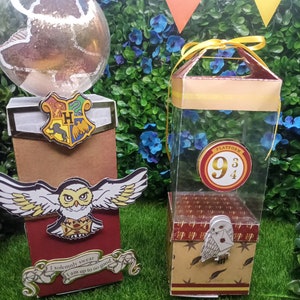 May include: Two Harry Potter themed gift boxes. One box is red and features the Hogwarts crest and a white owl with a letter. The other box is brown and has a clear plastic window with a red circle that says "Platform 9 3/4". Both boxes have a white owl with a letter.
