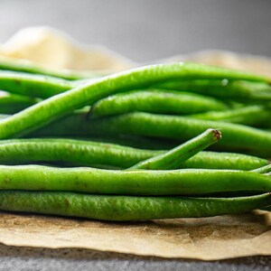 a pile of green beans sitting on top of a piece of paper