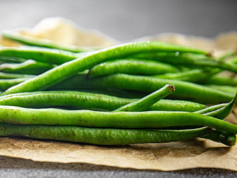 a pile of green beans sitting on top of a piece of paper