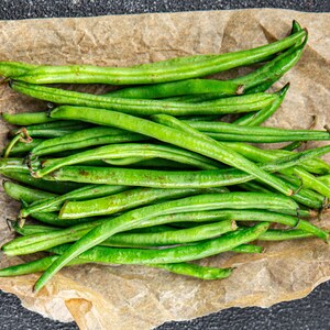 a bunch of green beans sitting on top of a piece of paper