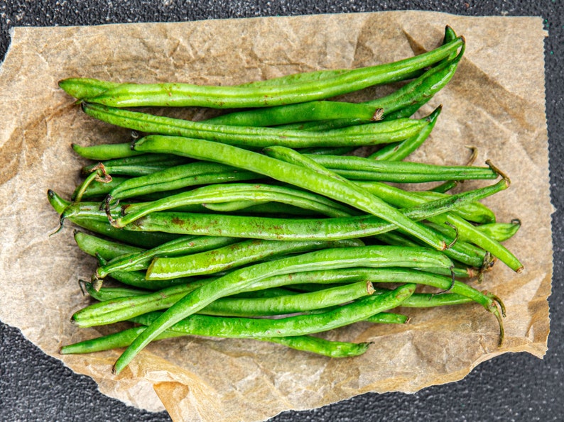 a bunch of green beans sitting on top of a piece of paper