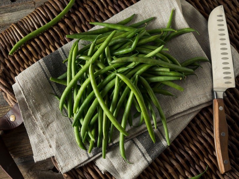 a bunch of green beans sitting on top of a table