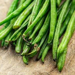 a bunch of green beans sitting on top of a piece of paper