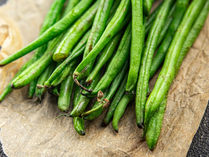 a bunch of green beans sitting on top of a piece of paper