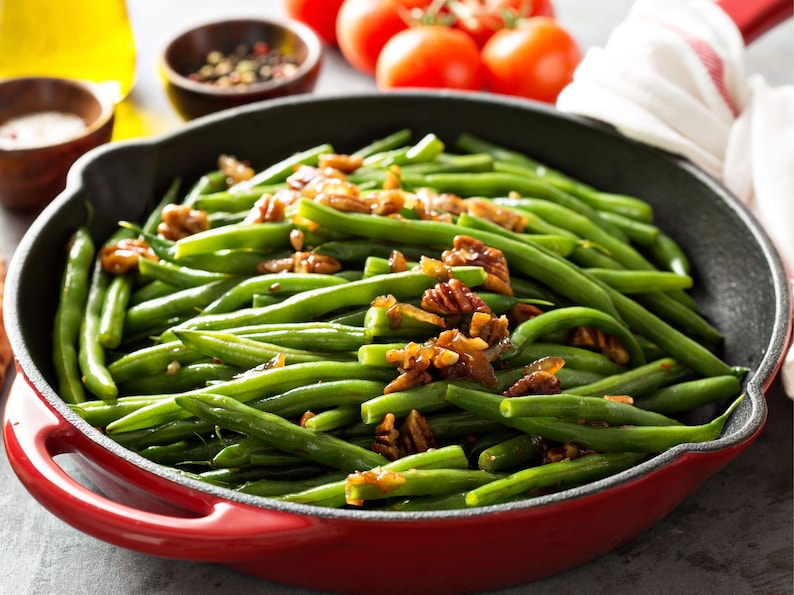 a pan filled with green beans and walnuts