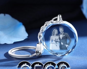 May include: A silver keychain with a clear crystal charm featuring a 3D engraved image of a couple. The crystal charm is faceted and has a round shape. The keychain is a great gift for a wedding or anniversary.