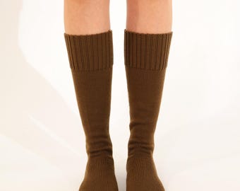 May include: A pair of knee-high socks in a solid brown color. The socks have a ribbed knit cuff and a smooth knit leg. The socks are made of a soft, comfortable material.