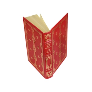 May include: A red hardcover book with gold lettering on the spine. The title is "Pride and Prejudice" by Jane Austen.