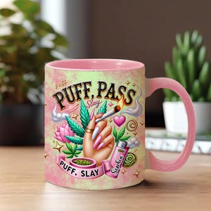 May include: Pink and white ceramic mug with a pink handle and rim. The mug features a hand with long pink nails holding a lit cigarette, marijuana leaves, and the words "Puff, Pass, Slay". A lighter with the name "Sophia" is also shown.