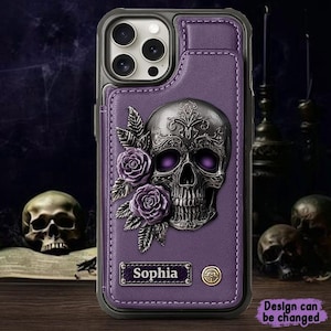 Puede incluir: Funda de teléfono morada con diseño de calavera y rosas. La funda presenta una calavera plateada con ojos morados, rodeada de rosas y hojas moradas. El nombre "Sophia" se muestra en una pequeña placa. La funda tiene un tarjetero.