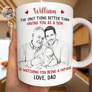 Op de afbeelding: Witte keramische mok met een familieportret en de tekst "William" en "Het enige dat beter is dan jou als zoon te hebben, is je als vader te zien. Love, Dad." De mok heeft een groot handvat.