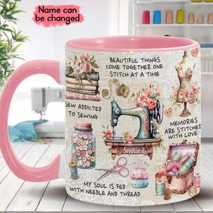 May include: Pink ceramic mug with a sewing themed design. The mug features a sewing machine, buttons, thread, scissors, and a quote that says "Beautiful things come together one stitch at a time".