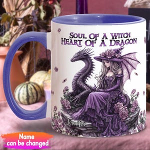 Könnte beinhalten: Eine weiße Keramiktasse mit lilafarbenem Rand und Henkel. Die Tasse zeigt einen lilafarbenen Drachen und eine Hexe mit einem lilafarbenen Kleid und Hut. Der Text auf der Tasse lautet "Soul of a Witch Heart of a Dragon" und "Jennifer".